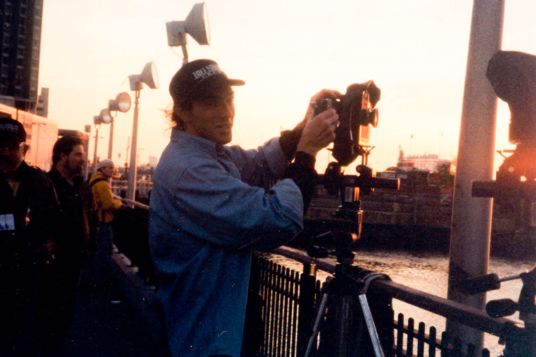 photographer adjusting a camera on a railing next to a canal in 19 99.