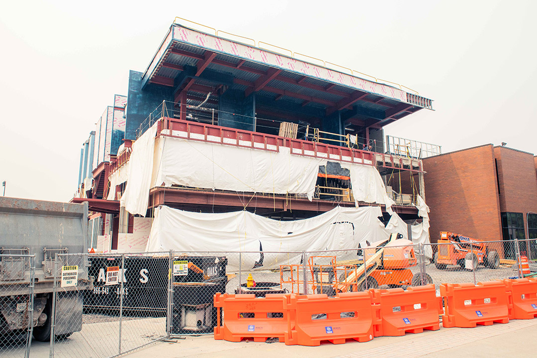 construction area of a building, covered in tarps and blocked off with fencing.