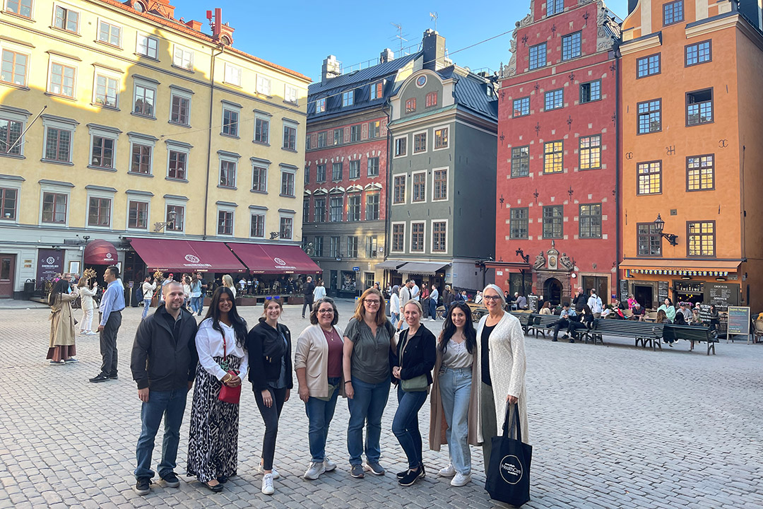 eight people posing for a photo in a brick courtyard in Sweden.