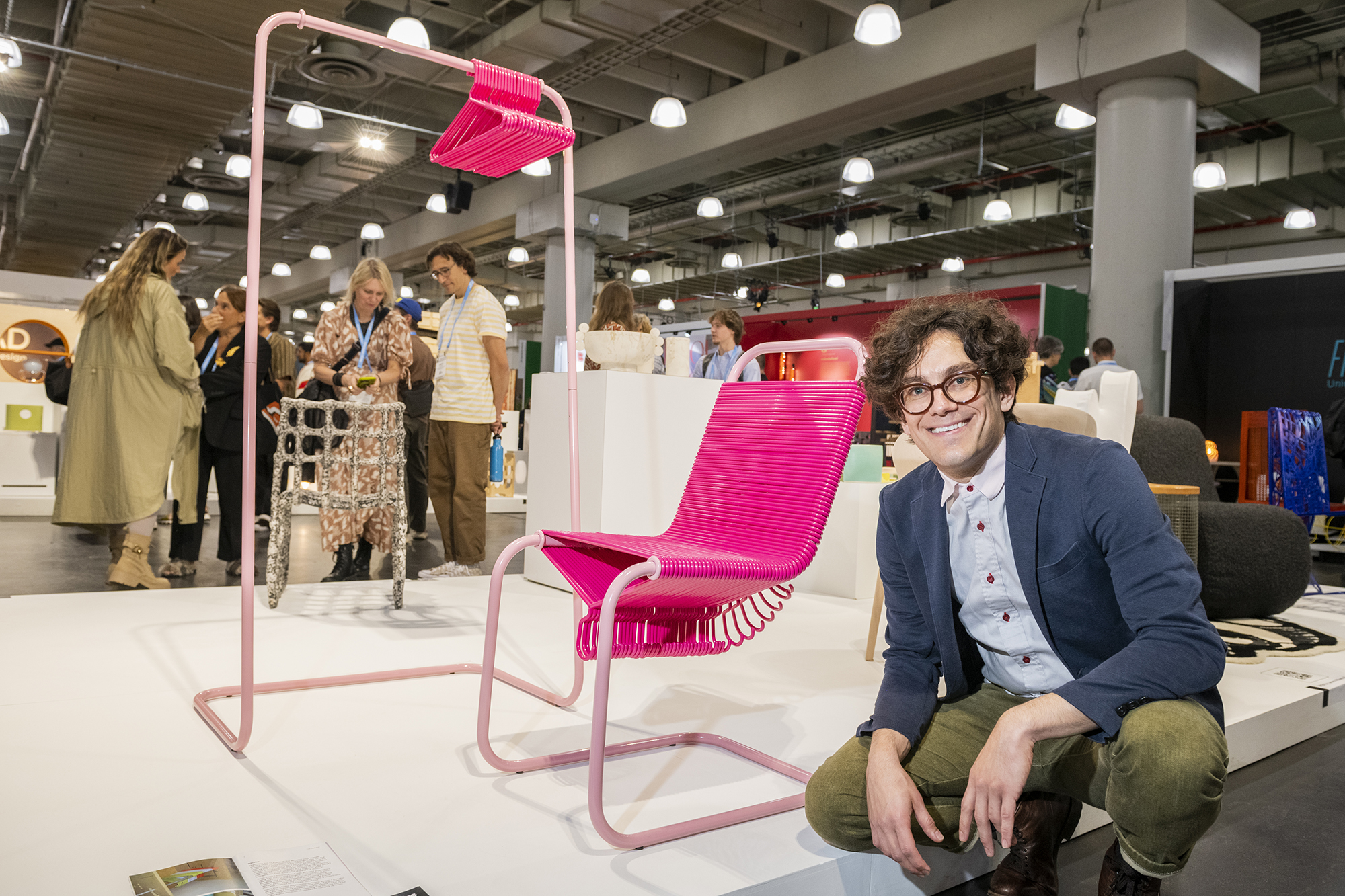 Joey Zeledon next to his Coat Check Chair on the floor of the WantedDesign event at the Javits Center.