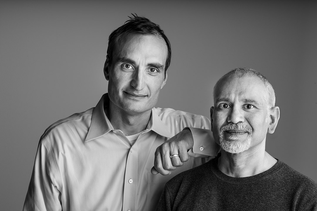 two researchers posing for a photo, with one resting his arm on the other's shoulder.