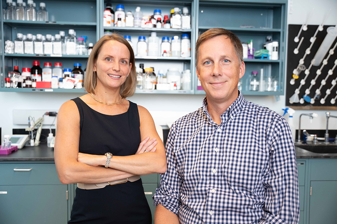 two researchers standing next to each other in a lab.