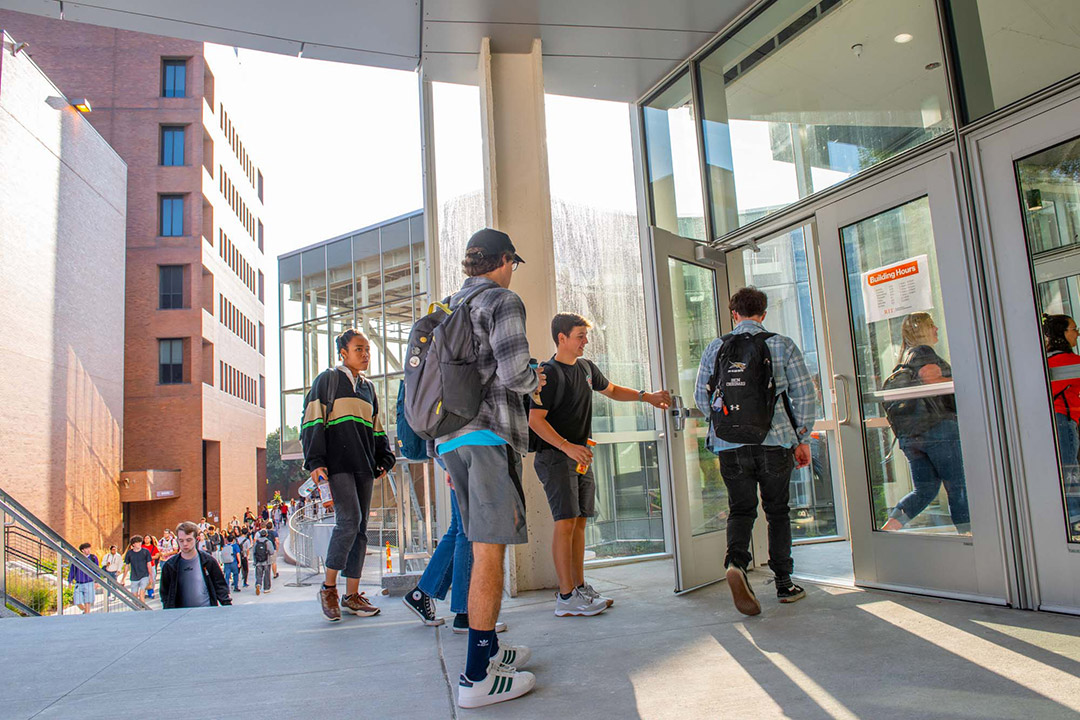 four college students walking into a building.