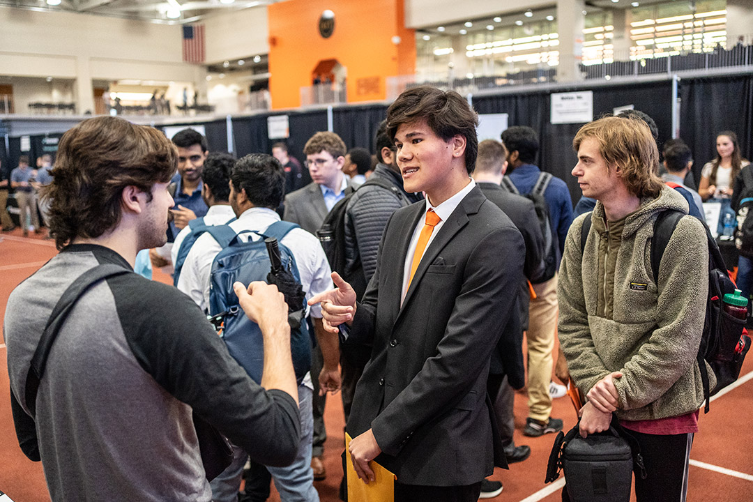 college student at a career fair talking to a recruiter.