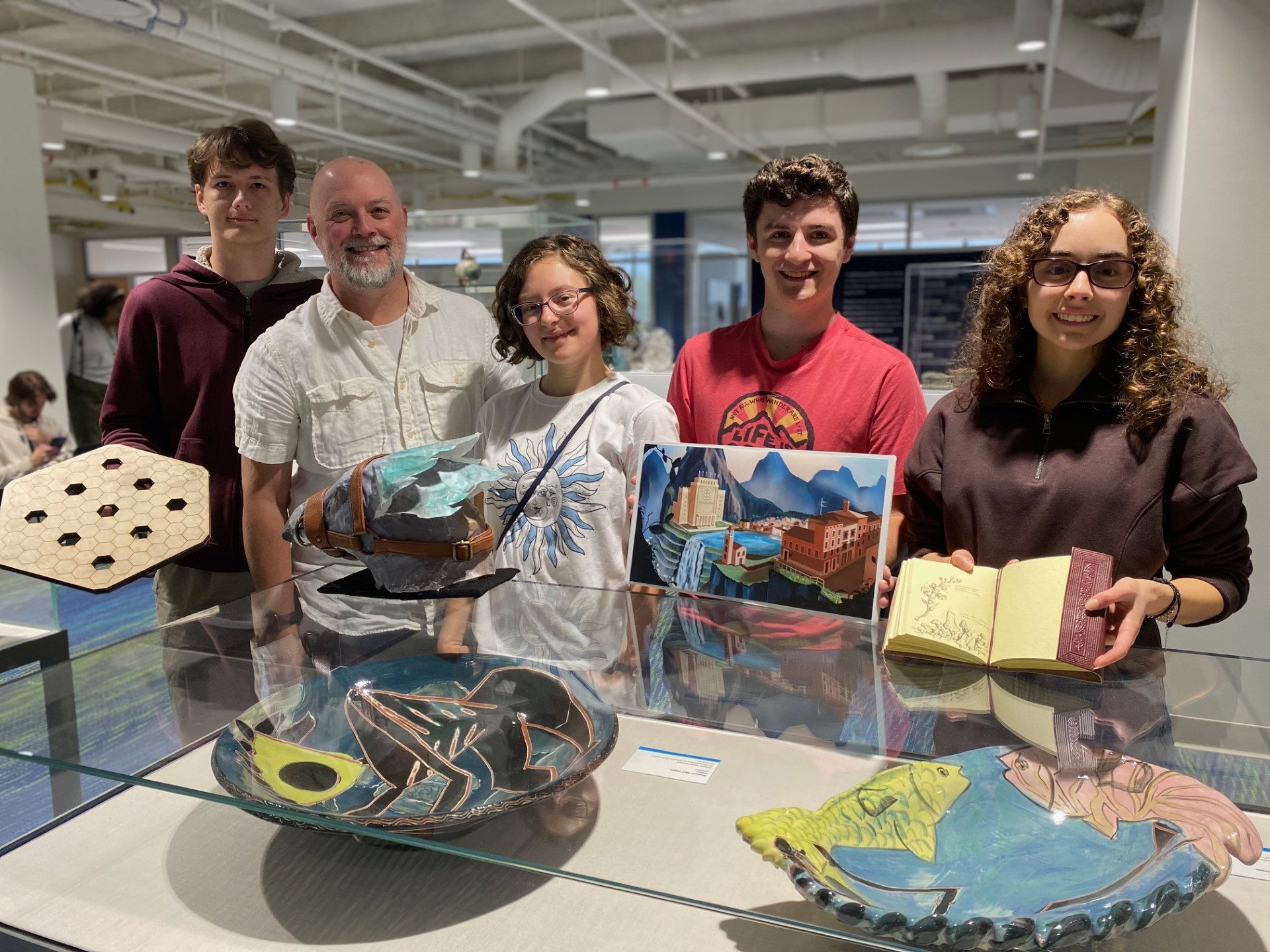 a photo of trent and students holding worldbuilding artifacts
