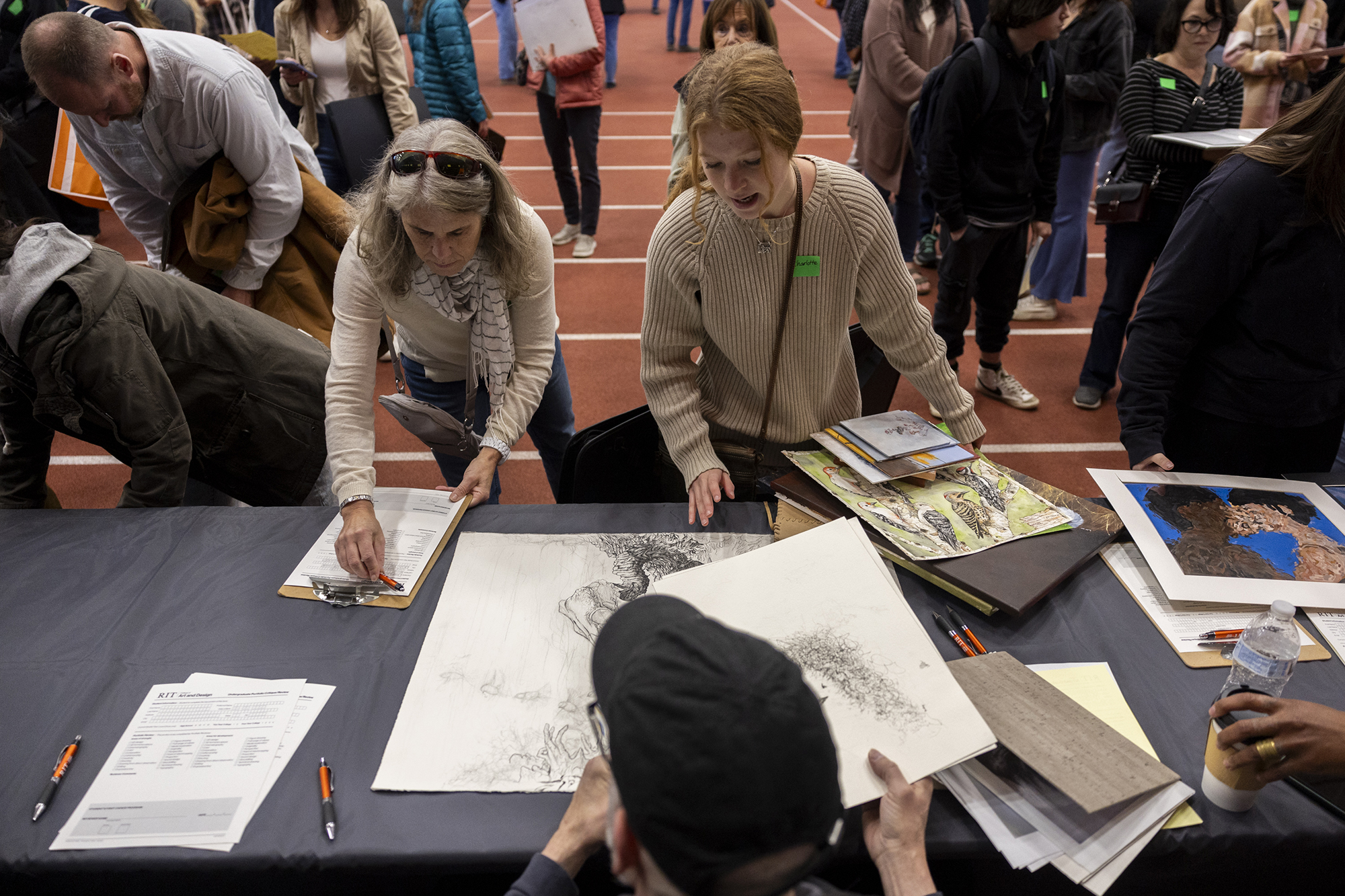 A student has her artwork reviewed by faculty member Don Arday. 