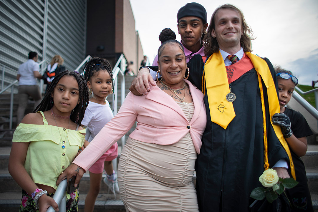 family of five posing around a college graduate.