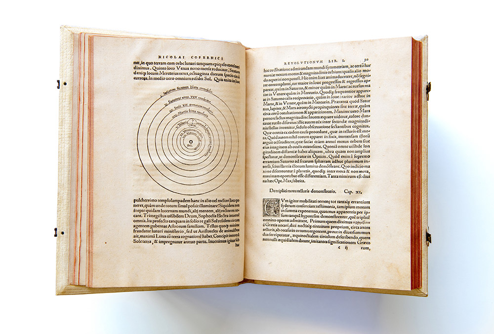 pages of a centuries old text penned by early astronomers Copernicus and Sacrobosco.