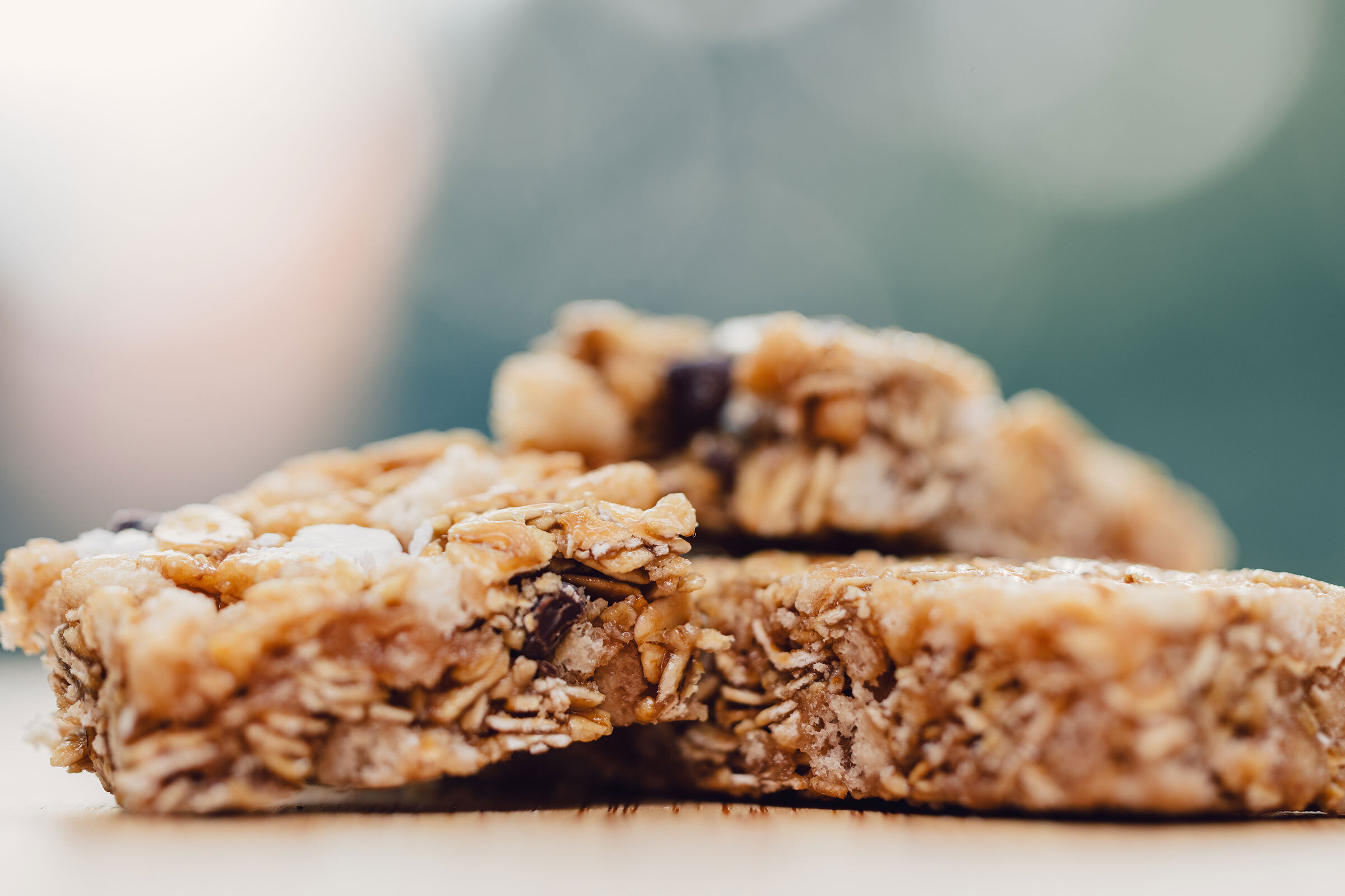 A close-up photo of granola bars on a wooden slab. 