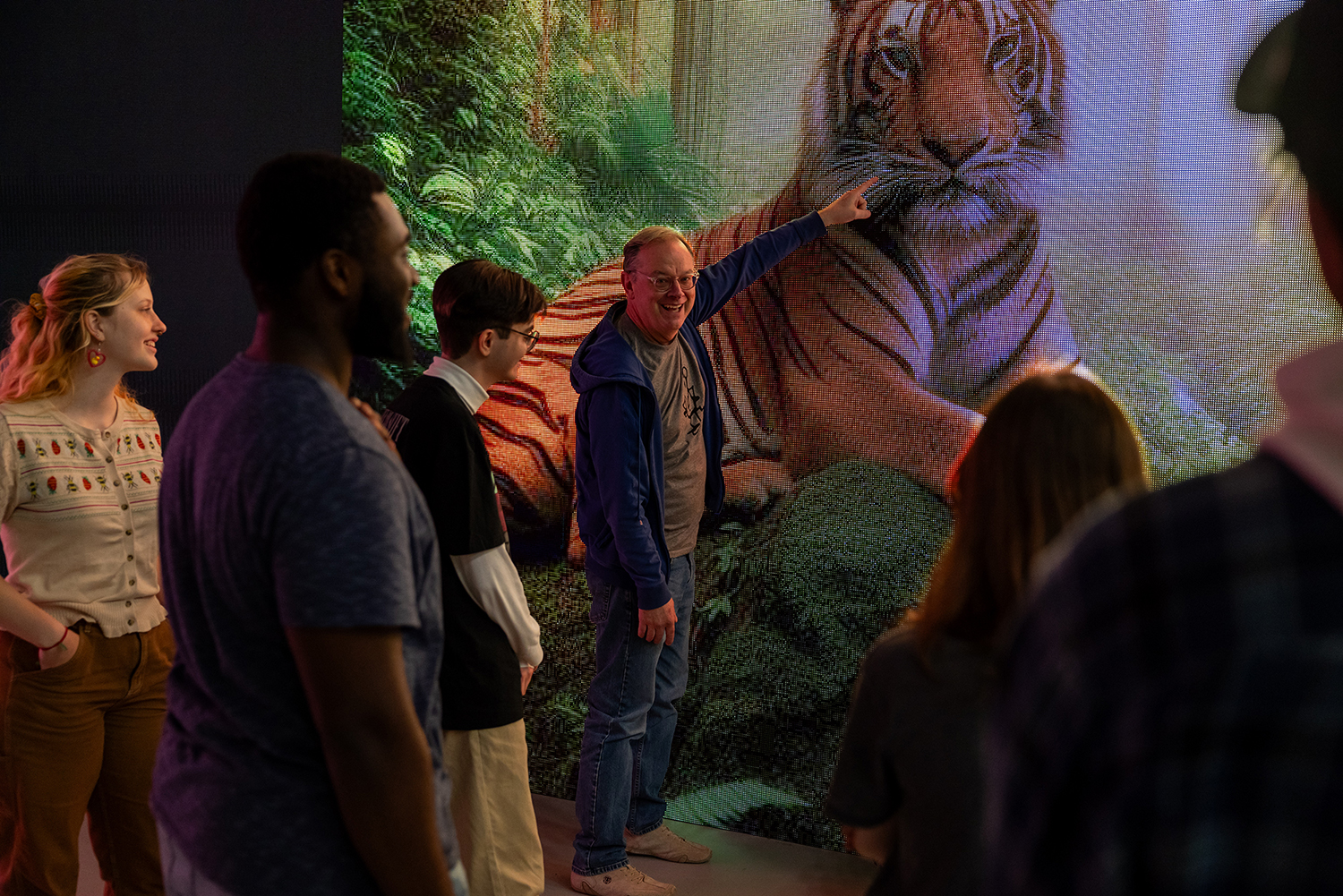 Flip Phillips points to a CGI tiger on a large LED screen.