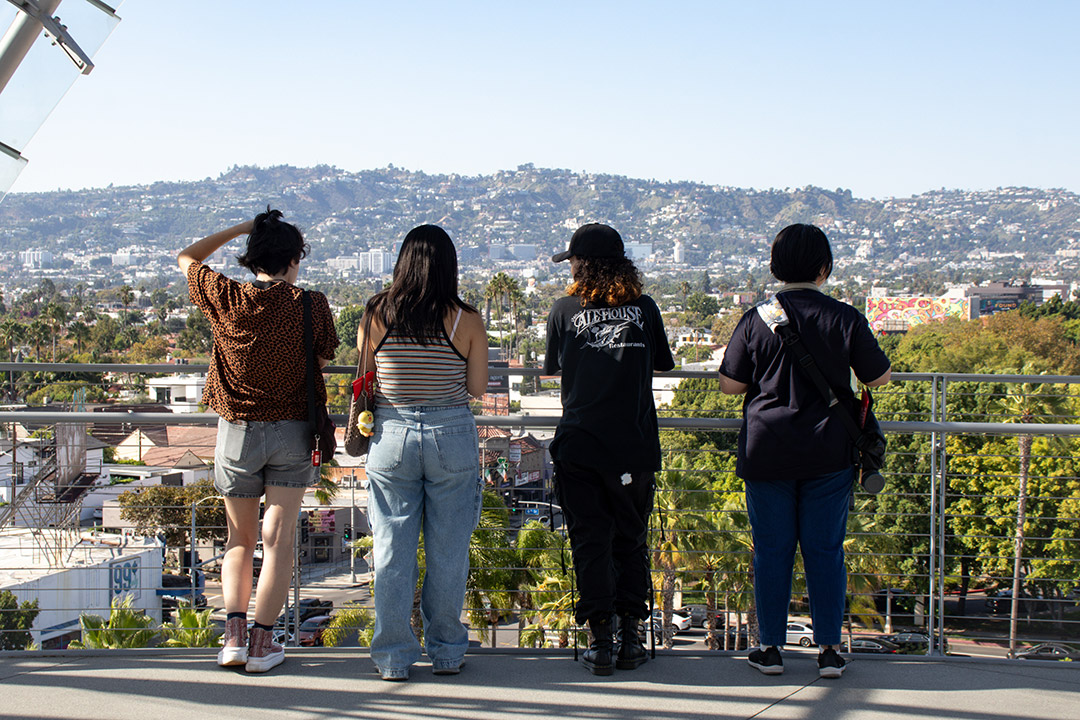 Students from the 2023 Study Away LA cohort look out over the city of Los Angeles from a balcony at the Academy Museum of Motion Pictures