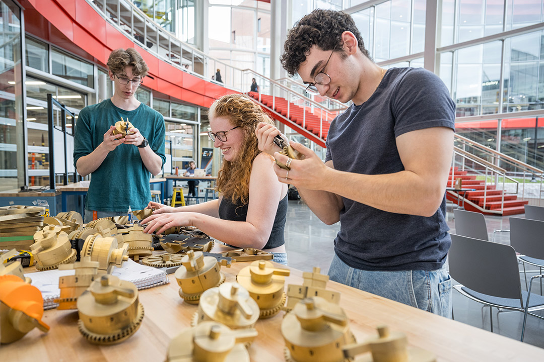 RIT student Catherine Hampp, center, assembles a stage prop for Ada and the Engine consisting of more than 100 3D printed parts made in the SHED. Her friends and RIT students Jack Smith, left, and Bailey Brown lend a hand. 
