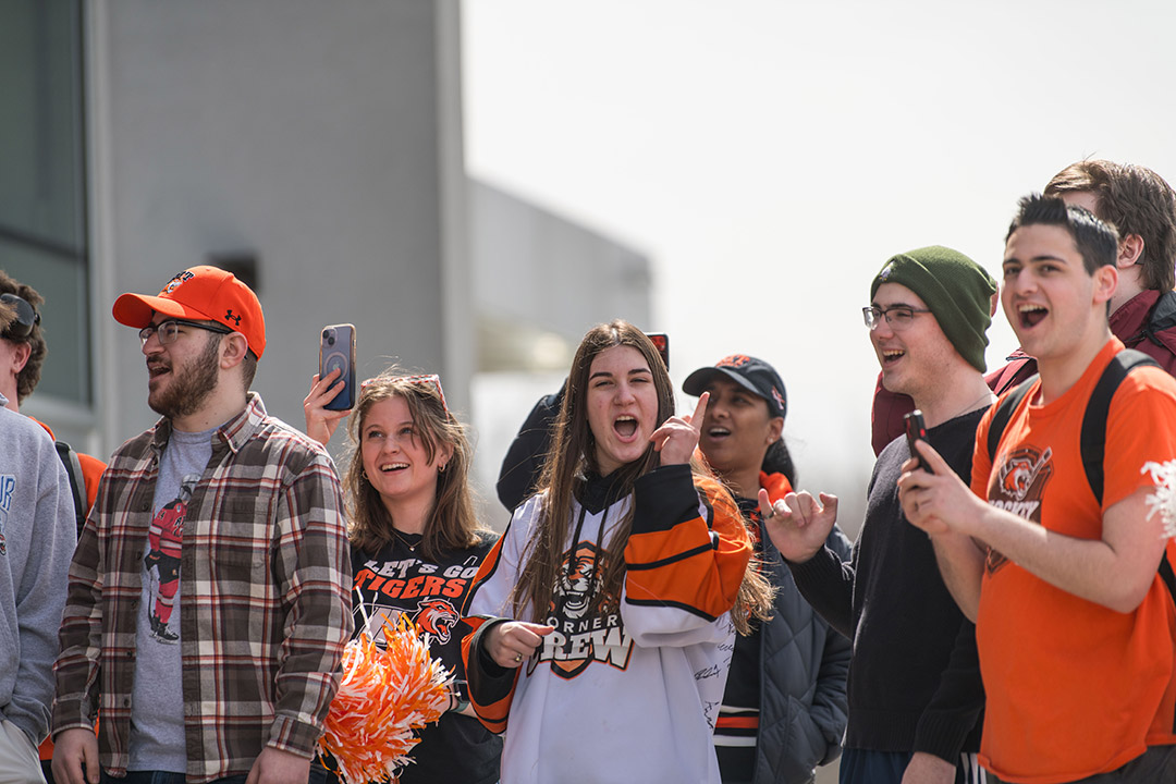 Julia Spazianiis shown cheering on the RIT men’s hockey team as they boarded a bus to the airport for their flight to the NCAA tournament in Sioux Falls, S.D. She wore a Corner Crew jersey with many team member autographs on the back. 