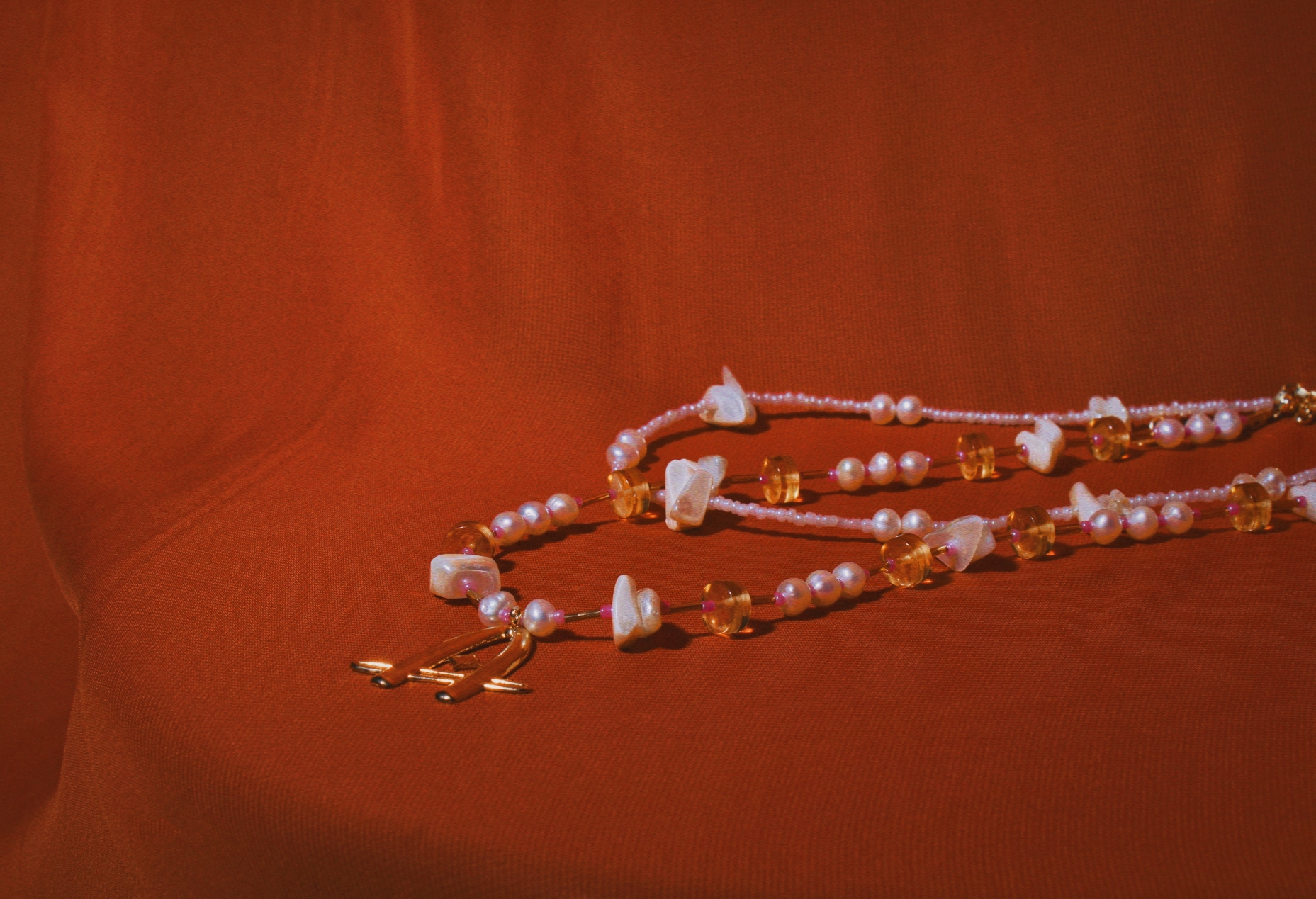 A beaded gemstone necklace set against a red background.
