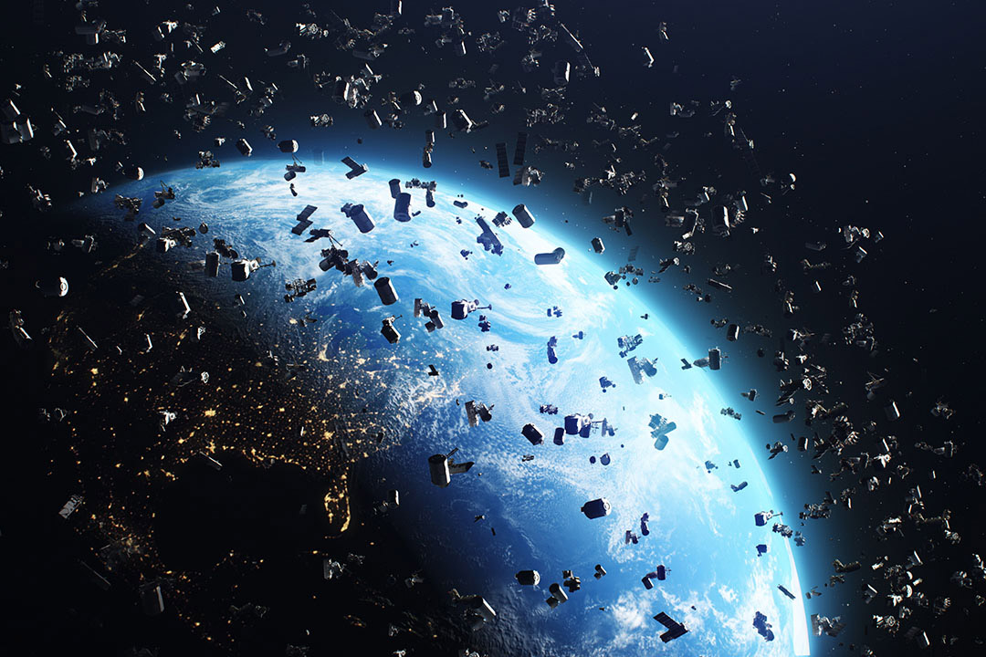 an image showing the earth from space in the background and tons of space debris floating around in the foreground.