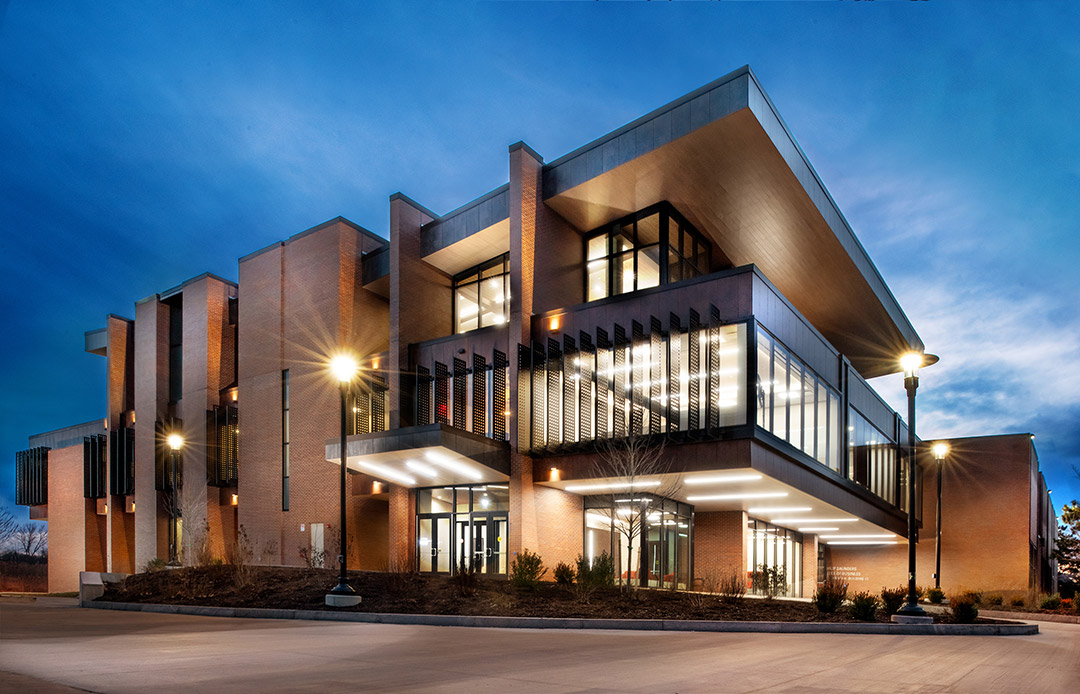 a photo of the Saunders College of Business building is shown in the evening.