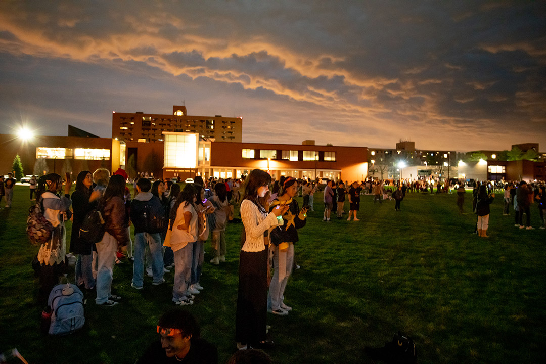 'throngs of students are shown in the RIT lawns during totality.'