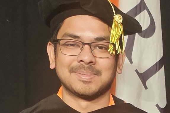 A photo of alumnus Purab Sutradhar wearing a doctoral hood and cap at RIT commencement.