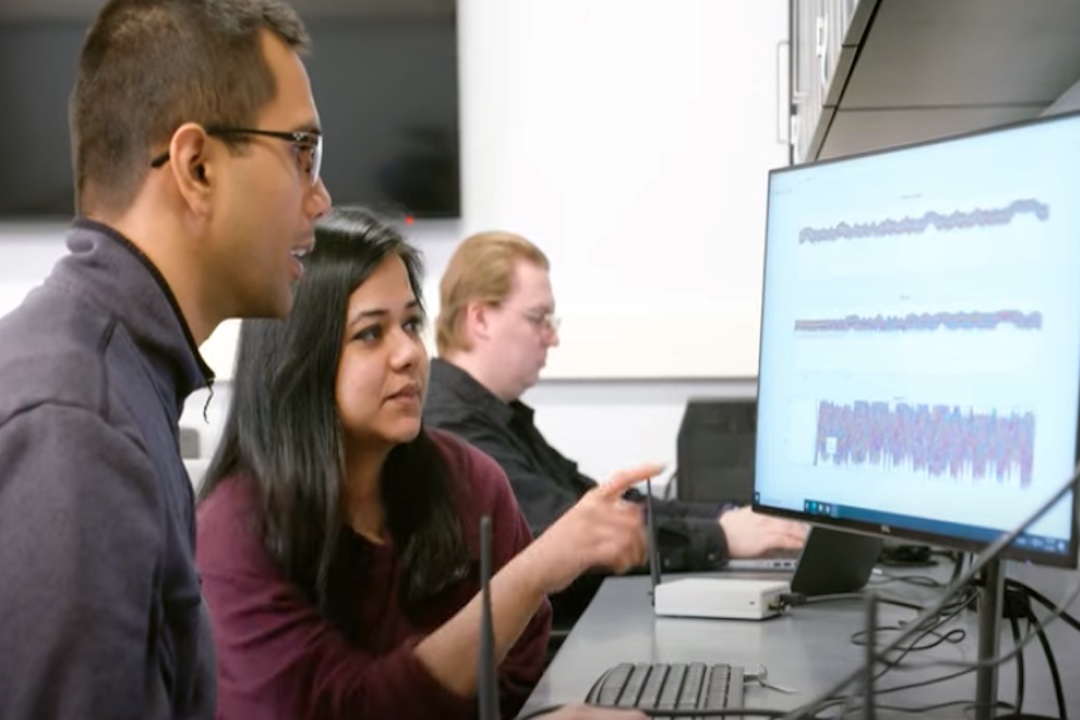 Student Naureen Hoque points at a computer screen displaying waveforms