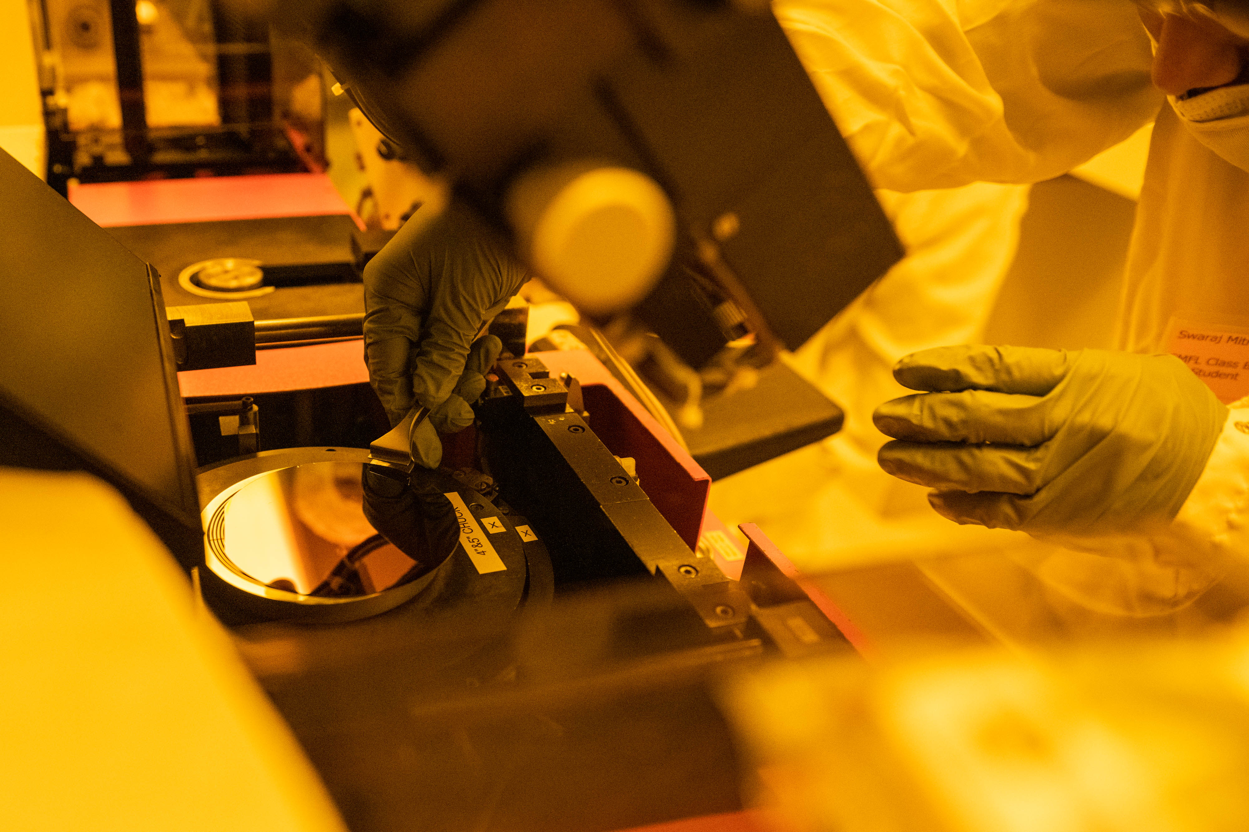 A close up shot of a gloved hand working with semiconductor