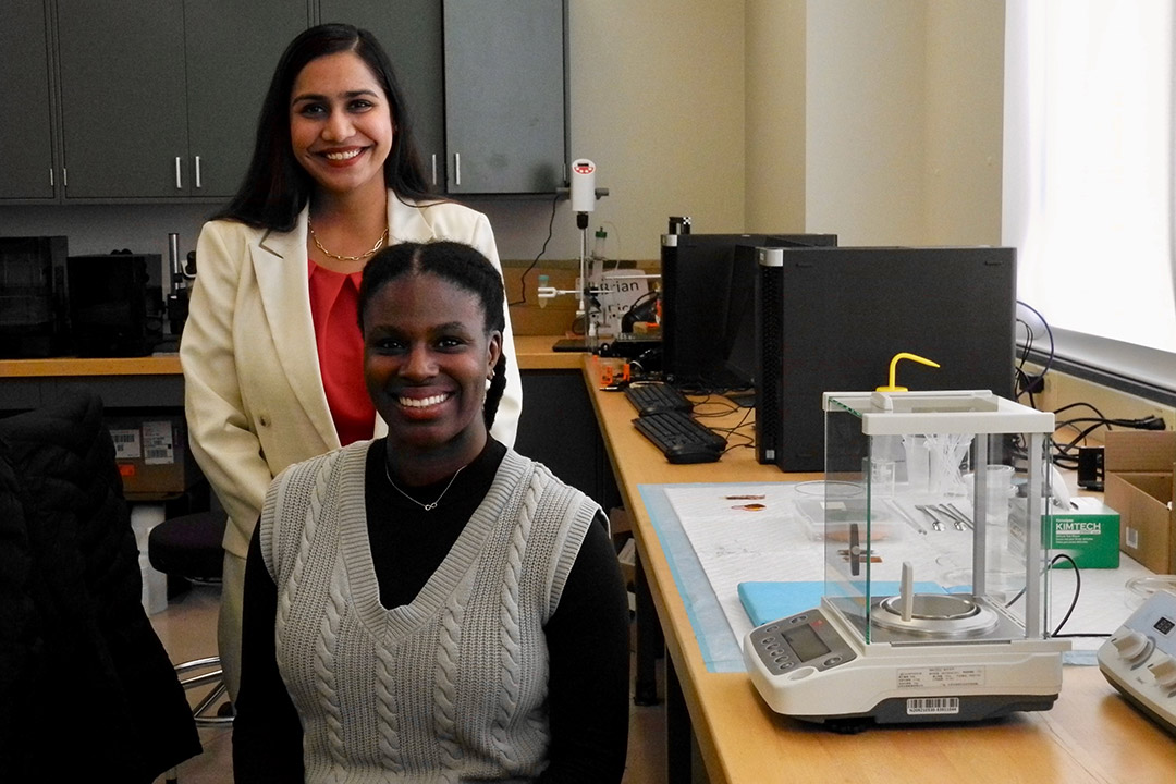 Leila Dal is seated in front of Krittika Goyal in a lab of sensors for prosthetics. 