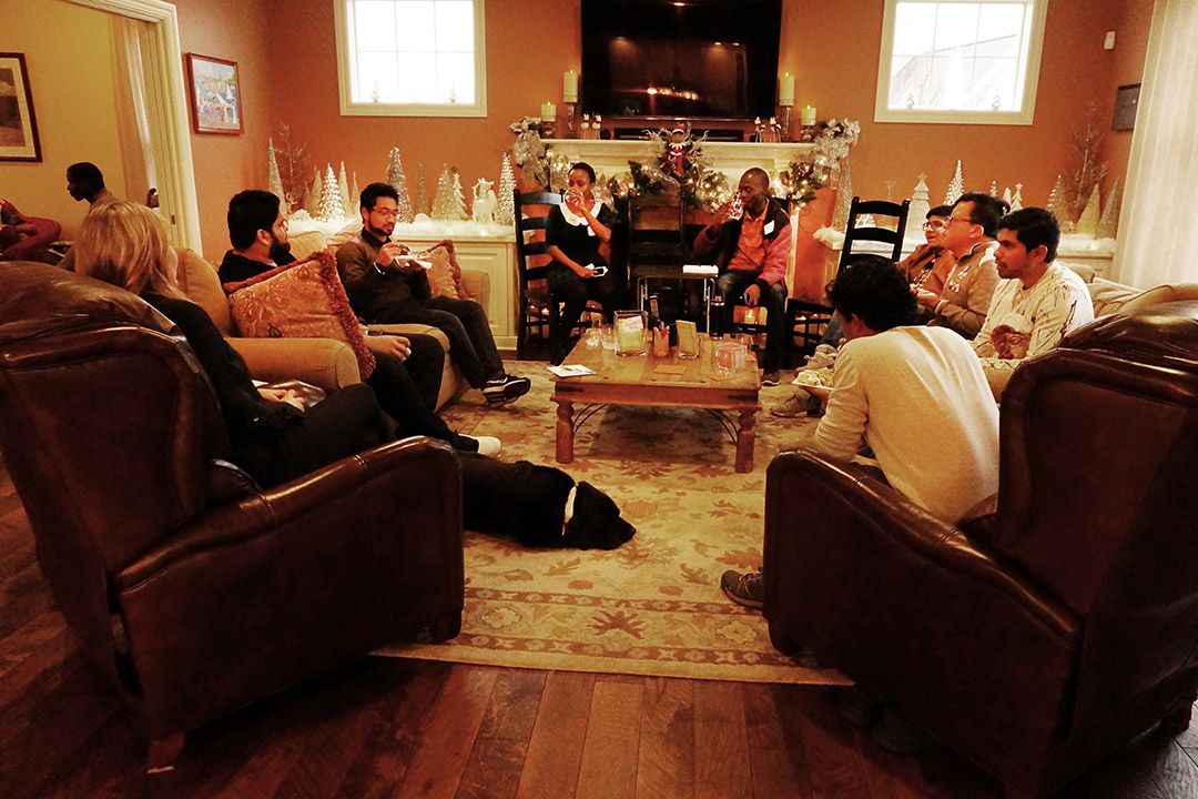 People gather in living room decorated for the holidays.