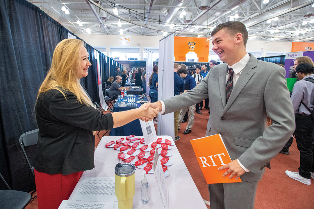 a man and woman shake hands at a table