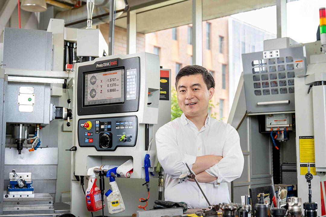 'a man in a white shirt stands in a lab.'