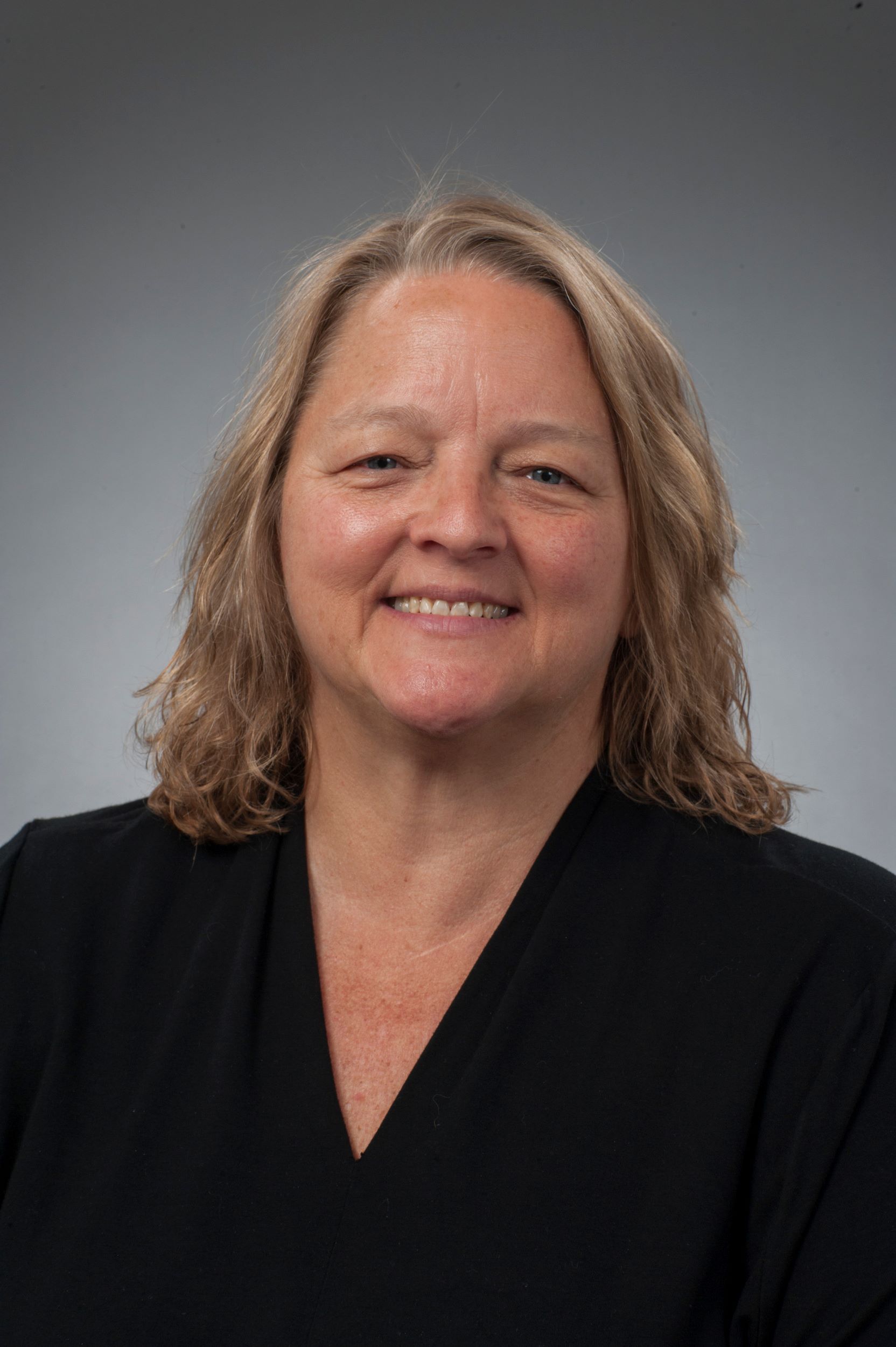 Close up of Pamela Conley wearing a black v-neck top. She is smiling.