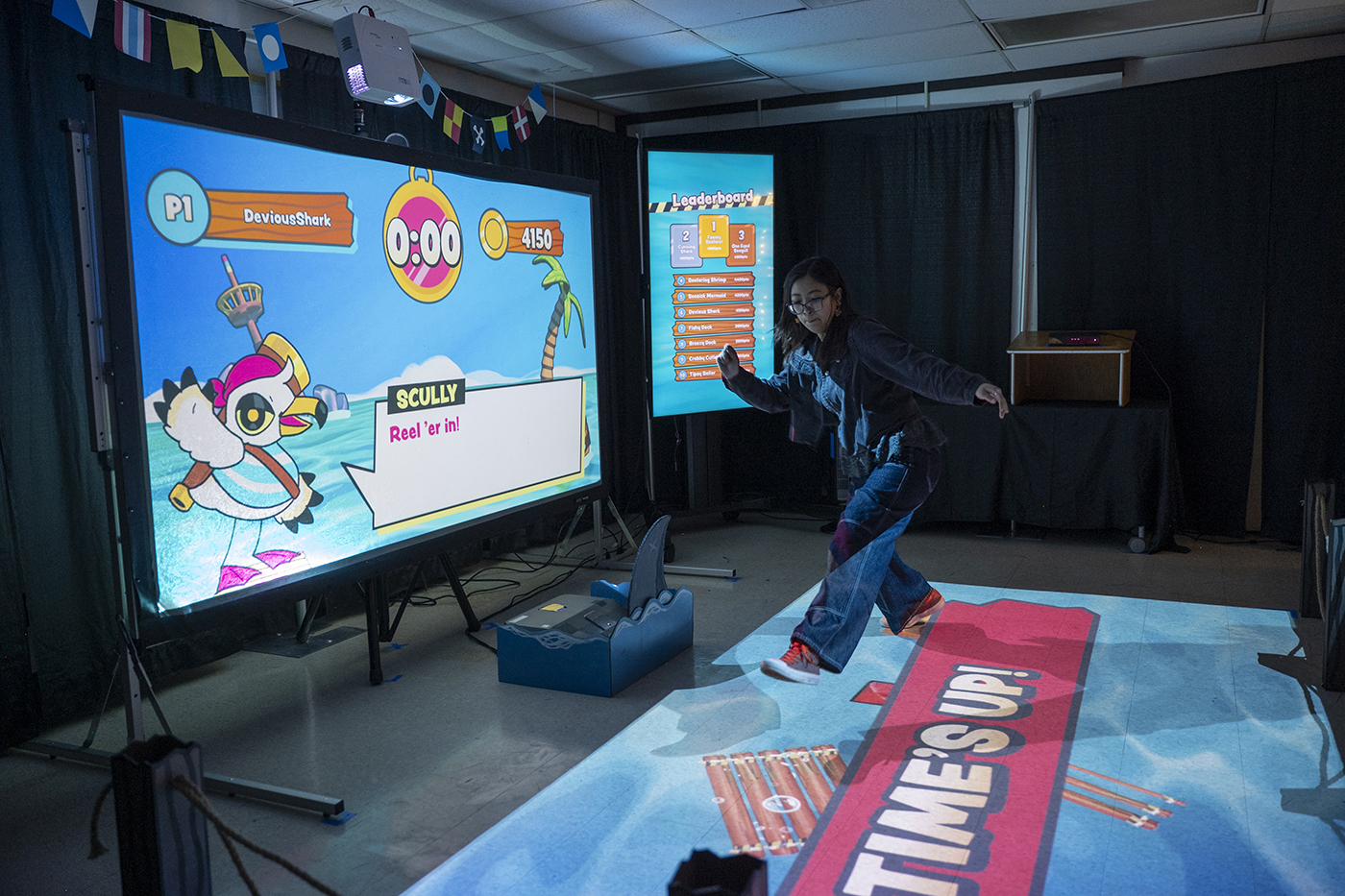 An Imagine RIT visitor jumps while participating in an interactive exhibition called Overboard.