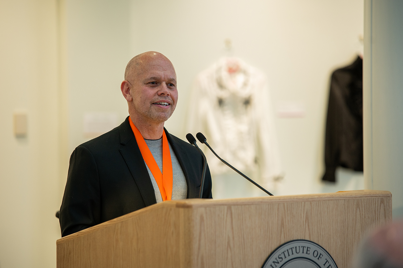 Ricky Figueroa talks into a microphone at a podium.