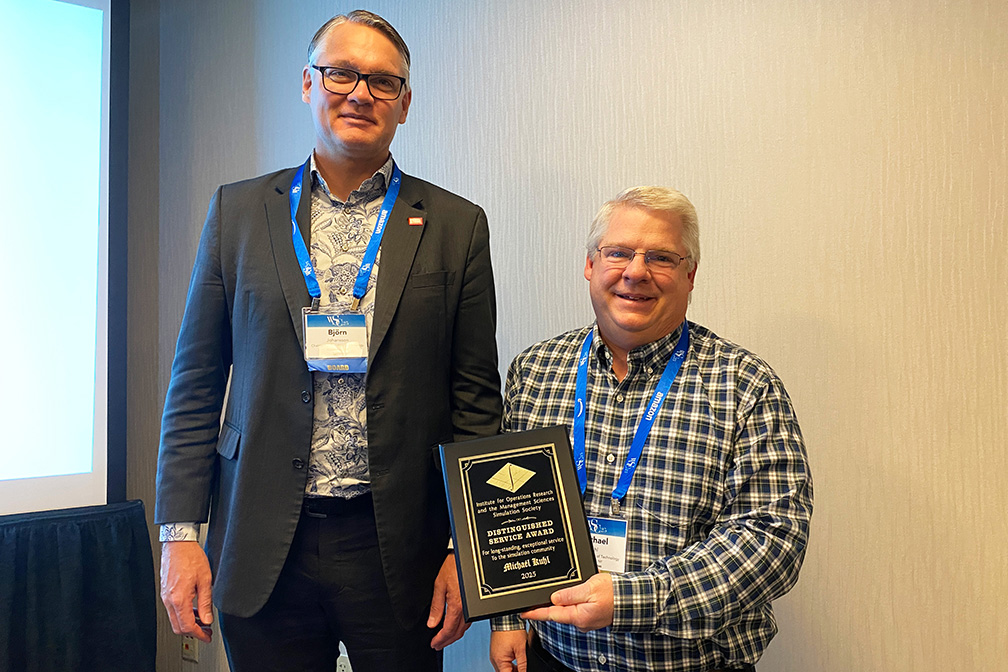 'Björn Johansson standing next to Michael Kuhl. Michael is holding an award plaque. '