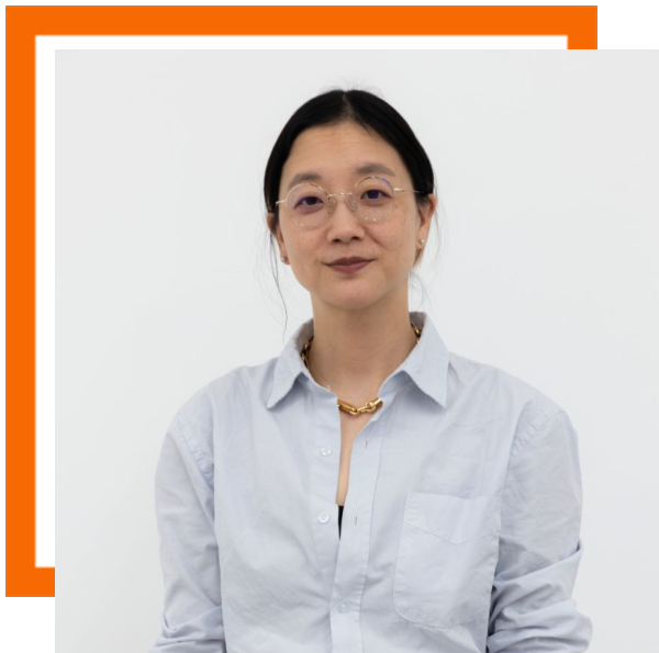 image of Chrstine Sun Kim wearing a light blue shirt and glasses, hair pulled back. She is against a white background. 