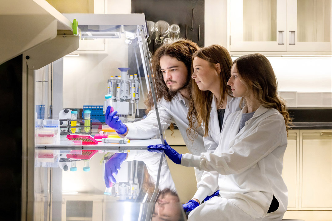 Assistant Professor Elle Barnes, center, works with students William Goyette, left, and Lilly Rennie, right, in the MEGA Lab on RIT’s campus. 