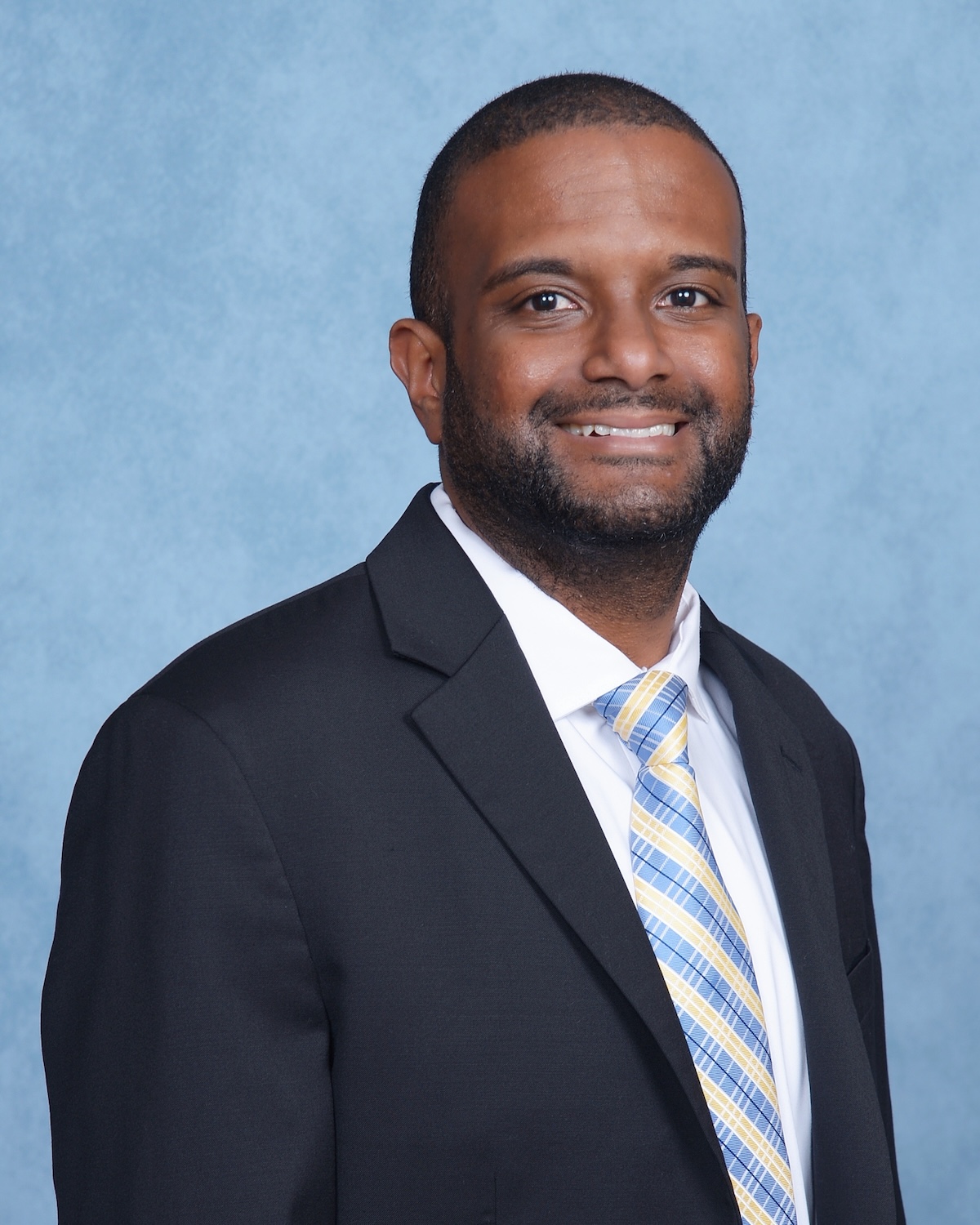 Studio portrait of a person in a suit wearing a tie