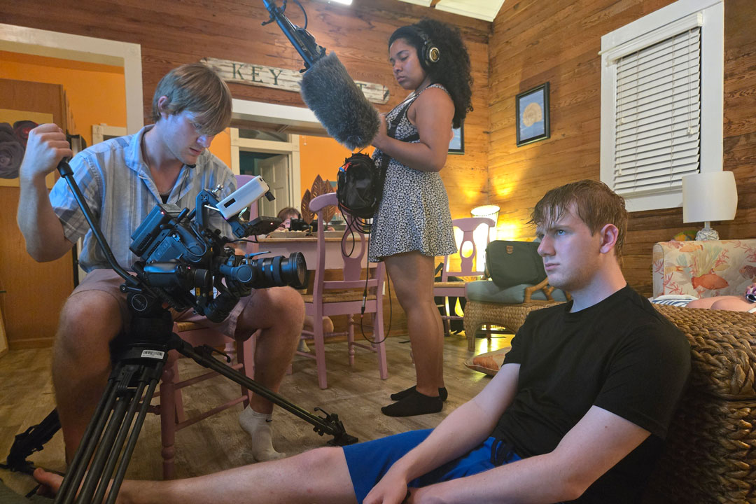 students film a scene in a cabin