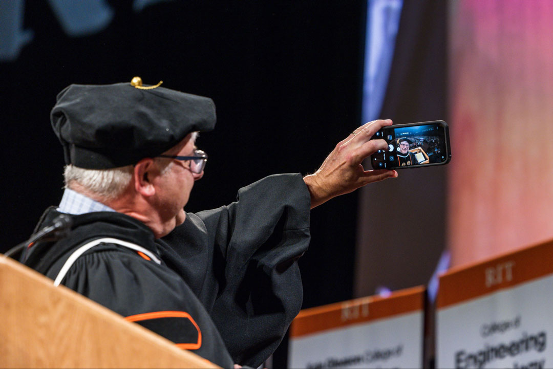 R I T President Bill Sanders takes a selfie with a new class of incoming students in the background