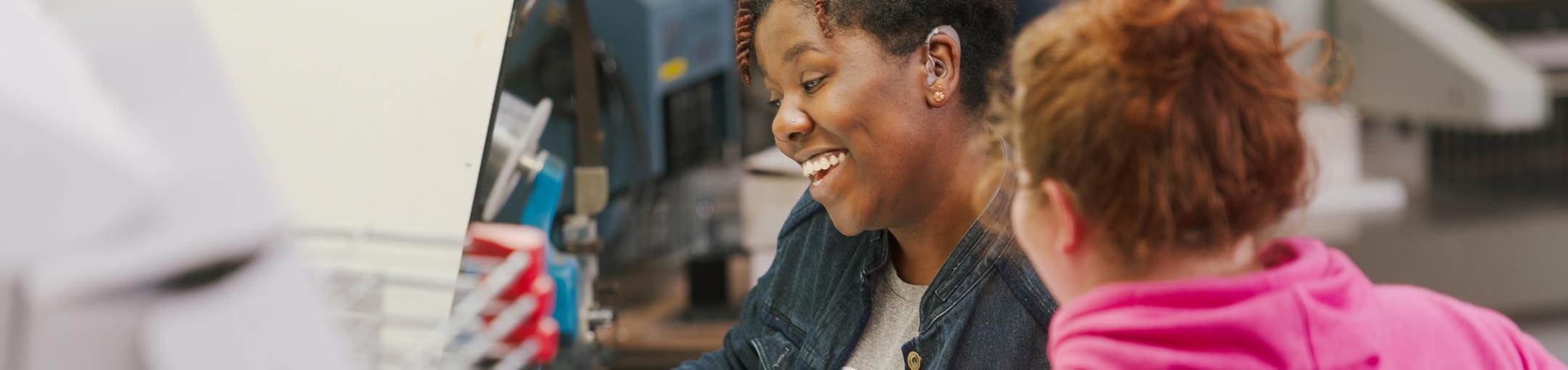 Two female students laughing in a lab.