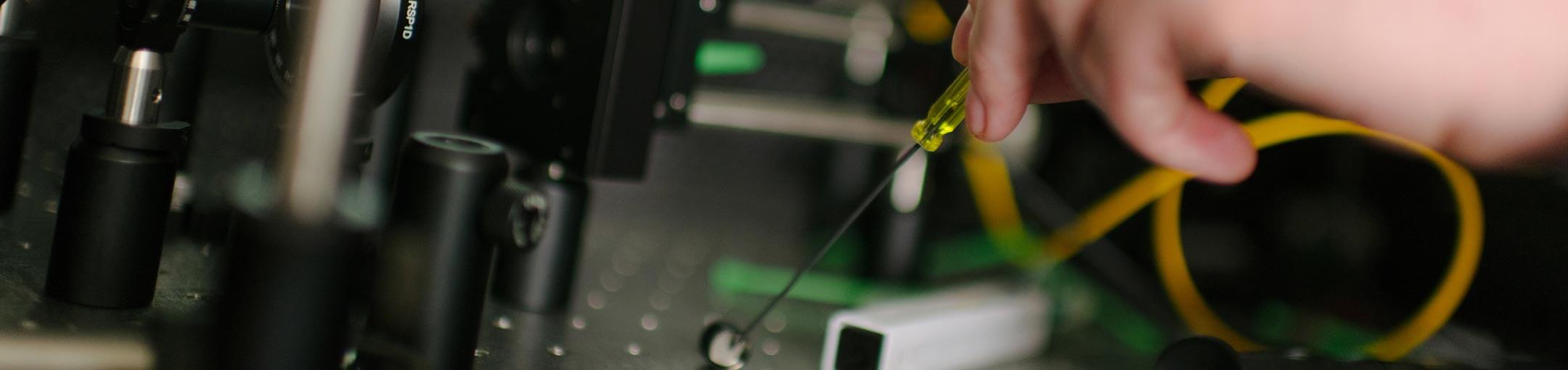 Close up of hand working on circuit board.