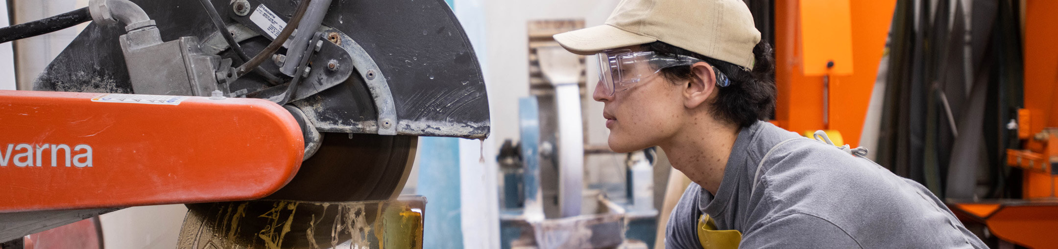 Person watches circular saw cutting through material.