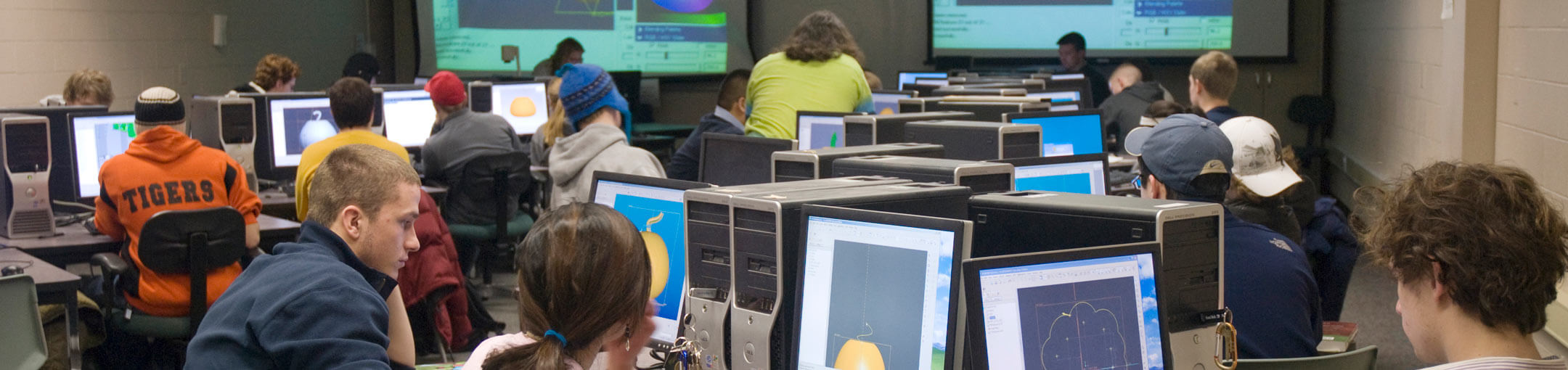 Group of students working in a computer lab with two projectors.