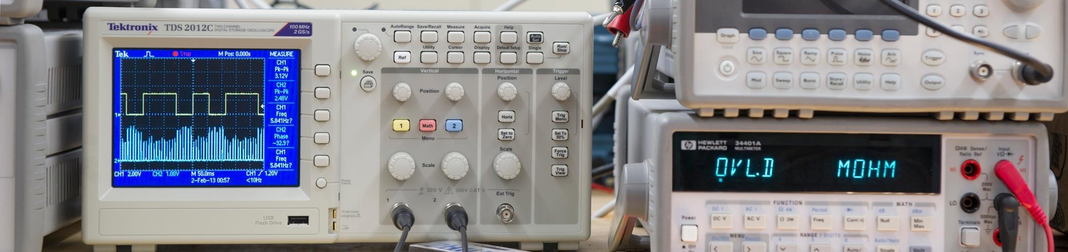 Close up of electrical euipment with displays, several buttons, and connected wires.