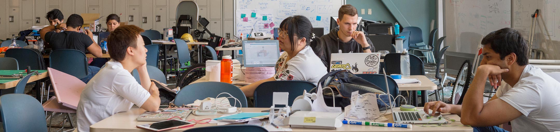 Students in a large lab/workspace create various constructions
