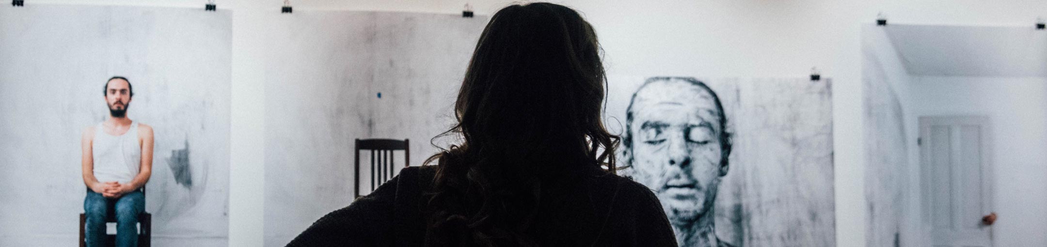 Person looking at photographs in a art gallery