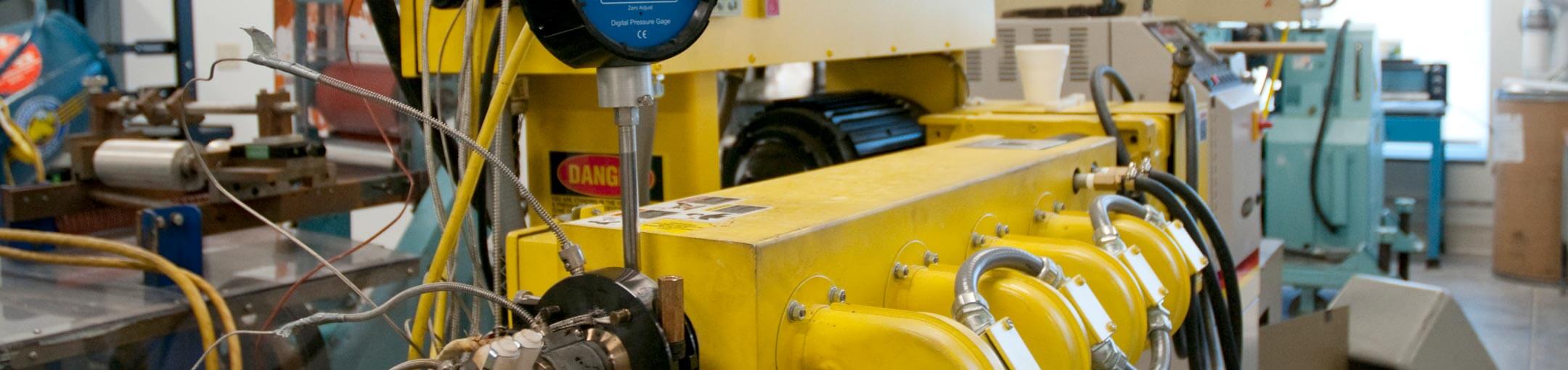 Close-up photo of yellow manufacturing equipment.