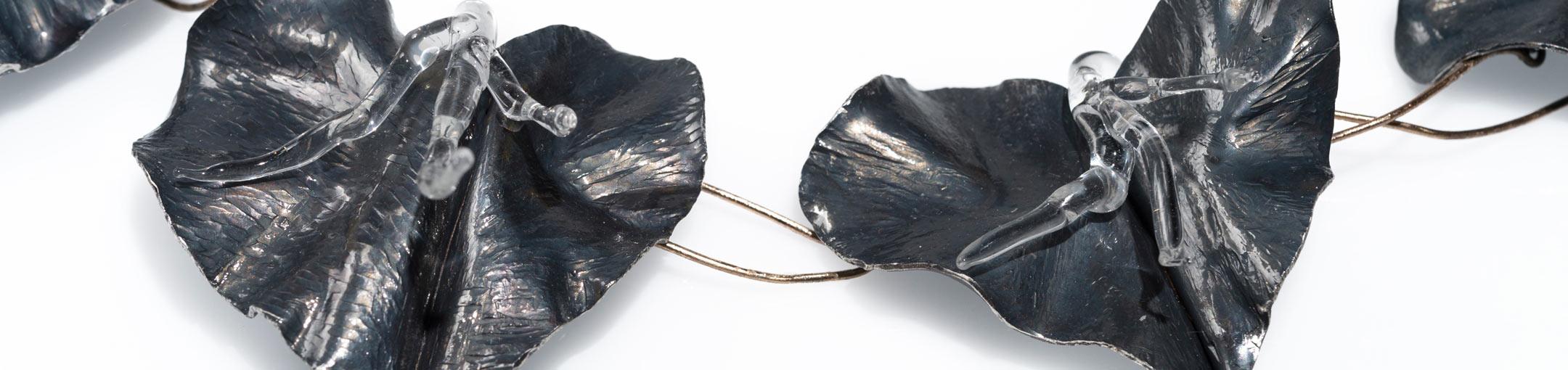 Dark petal-like forms attached to a wire