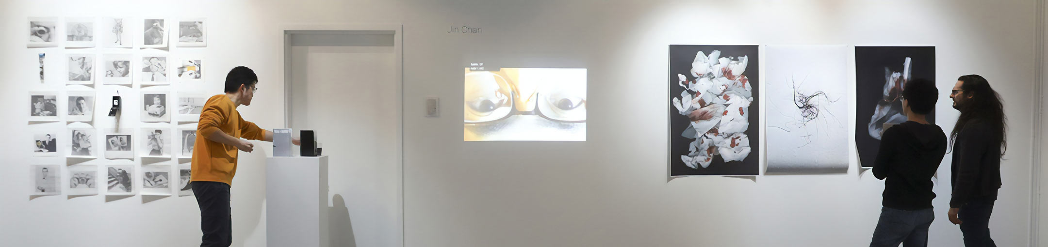 Students in a gallery looking at photos and other artwork
