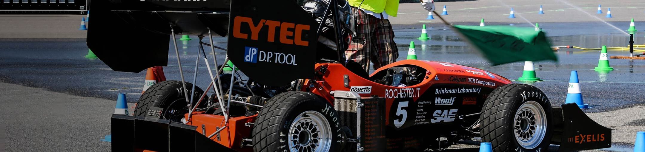 RIT's Formula SAE car with light blue cones around it.