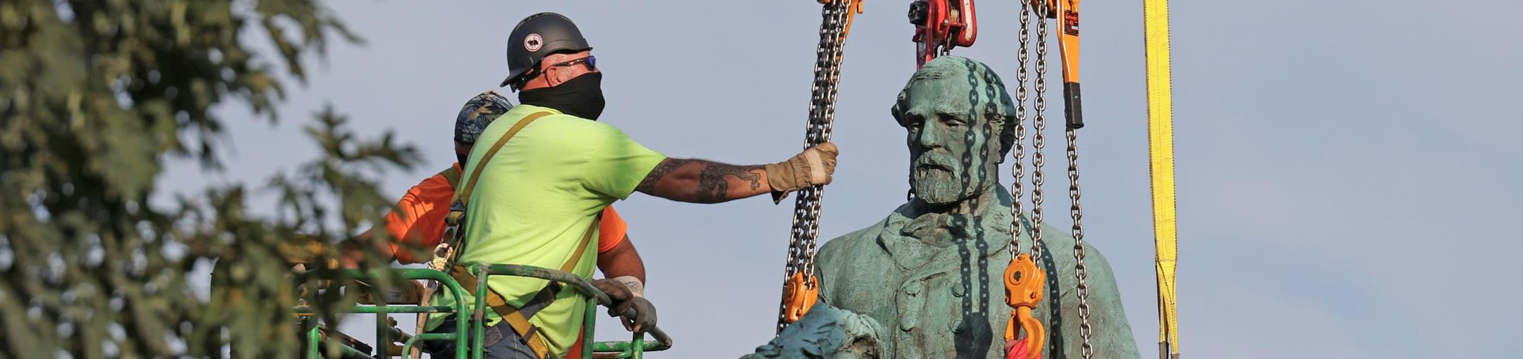 Workers remove a statue of Robert E. Lee.