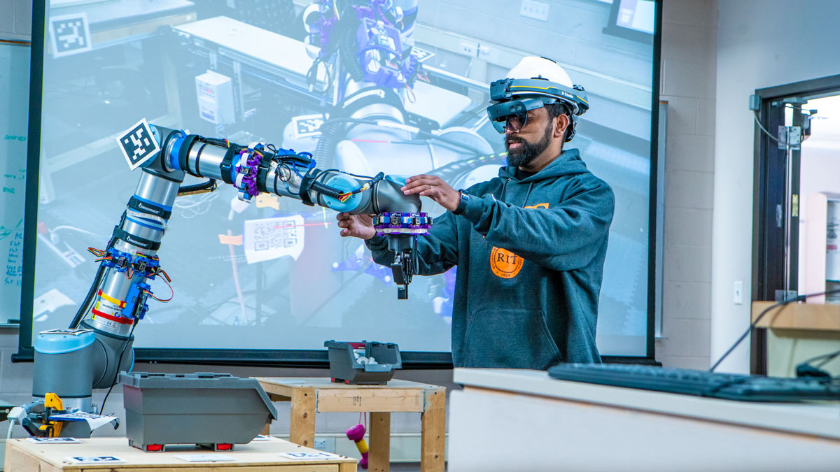 A student works on a mechanical arm.